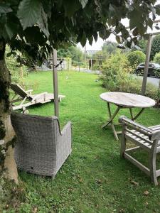 a table and a chair and a table and a table and a picnic table at Les studios du Domaine d'Eva in Libramont