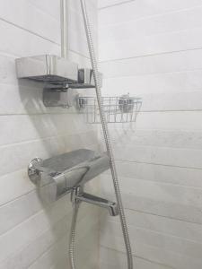 a shower with a hose attached to a wall at Professionals Friendly with Work Station PS5 & near Beaches in Lekki +74 photos