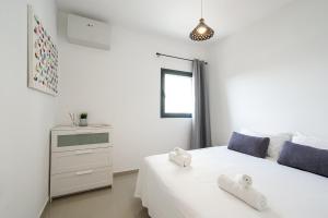 a white bedroom with two white towels on a bed at Luxury apartment with Sea View by Airsuite in Ashdod