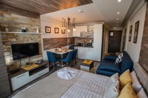 a living room with a bed and a kitchen at DeltaLux apartmani Milmari Kopaonik in Kopaonik