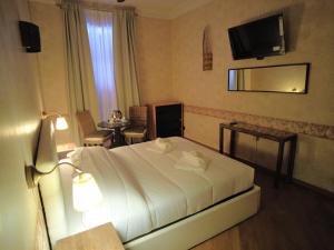 ein Hotelzimmer mit einem Bett und einem TV in der Unterkunft Gardoce's Guest House in Rom