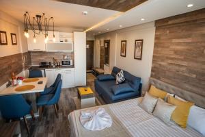 a room with a bed and a kitchen and a table at DeltaLux apartmani Milmari Kopaonik in Kopaonik