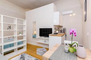 a living room with a table and a kitchen at Leonarda Baroque House - Old Town in Dubrovnik