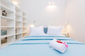 a white bedroom with a blue bed with white shelves at Leonarda Baroque House - Old Town in Dubrovnik +24 photos