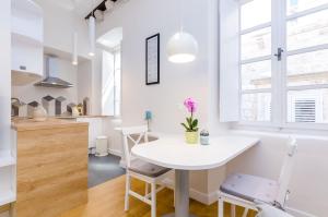 a kitchen and dining room with a white table and chairs at Leonarda Baroque House - Old Town in Dubrovnik