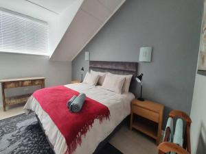 a bedroom with a large bed with a red blanket at Santos Beach Pavilion E in Mossel Bay