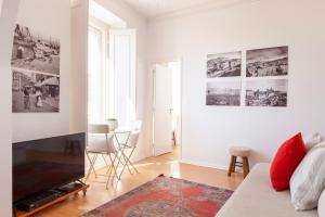 a living room with a couch and a tv at Alfama Amazing Scenic River and City View Charming apartment With 2 bedrooms and AC 19th Century Building in Lisbon