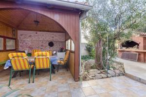 a patio with a table and chairs in a backyard at Apartments Franciska in Brodarica