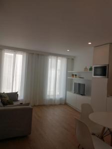 un salon avec un canapé, une télévision et une table dans l'établissement Bairro da Apresentação no coração de Aveiro, à Aveiro