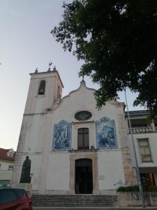 une église avec une tour recouverte de carreaux bleus dans l'établissement Bairro da Apresentação no coração de Aveiro, à Aveiro