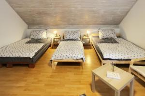 a room with three beds and a table at Duna House Duna Ház in Tass