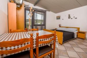 una camera da letto con un letto, un tavolo e delle sedie di Apartments Jakoubek a Podglavica