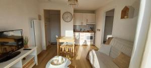 a living room with a couch and a kitchen at T2 cosy/balcon sud ouest/300m-mer/Villers sur Mer in Villers-sur-Mer