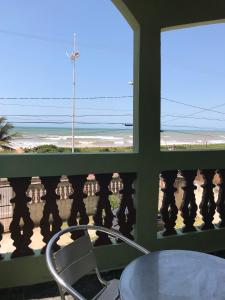 a room with a table and a view of the beach at Jacaraipe ES -Lar de Praia casa temporada in Jacaraípe