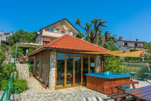 a house with a pavilion with a blue table at Apartments Ljiljana in Supetarska Draga