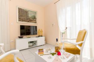 a living room with a tv and a table with wine glasses at Apartments Jerko in Sutivan