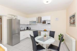 a kitchen and dining room with a table and chairs at Apartments Jerko in Sutivan