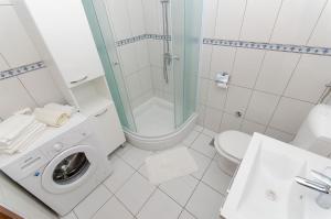 a white bathroom with a washing machine in it at Apartments Jerko in Sutivan +21 photos