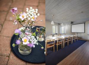 a dining room with a table with flowers and a screen at Ytterjärna Hotell & Konferens in Järna