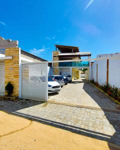 a parking lot with cars parked in front of a house at Villa Flecheiras in Flecheiras