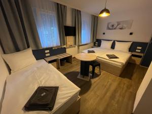 een hotelkamer met 2 bedden en een tafel bij Hotel Central City Hbf Nürnberg in Neurenberg