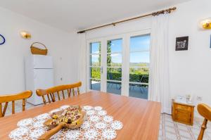a dining room with a table and a large window at Apartment Neven in Trogir