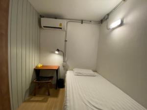 a small room with a bed and a table at My Home Hostel in Ban Na Kham