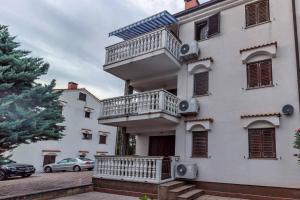 a building with a balcony on the side of it at Apartment Diracca in Malinska