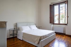 a white bedroom with a bed and a window at Re Dionisio Apartments con terrazza by Wonderful Italy in Siracusa