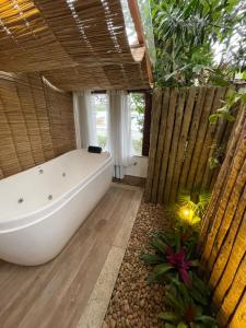 a large bathroom with a tub and a large window at Hotel Boutique Recanto da Passagem in Cabo Frio