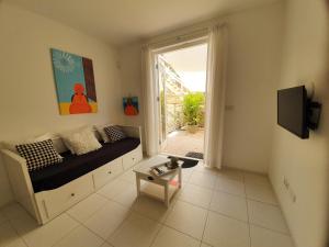 een woonkamer met een bank en een raam bij A2 APARTMENT budget at JAN THIEL Curacao in Jan Thiel