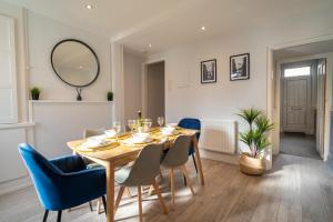 a dining room with a table and chairs and a mirror at Saltbox Stays- Large 3 bed house!! 3 bathrooms, garden, fast wifi, sleeps 6 in Swadlincote