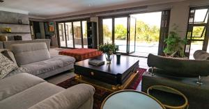 a living room with couches and a coffee table at Luxury Boutique Home in Kyalami in Midrand