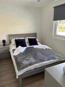 ein Schlafzimmer mit einem großen Bett mit blauen Kissen in der Unterkunft Chalet 208 In Glan Gwna Caernarfon in Caernarfon