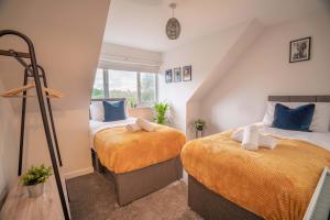 a bedroom with two beds in a attic at Saltbox Stays- Large 3 bed house!! 3 bathrooms, garden, fast wifi, sleeps 6 in Swadlincote