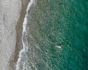 an overhead view of a person swimming in the ocean at Amalthia Villa, Heated Pool & Walk to the Beach, By ThinkVilla in Tavronitis