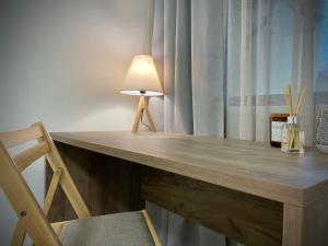 uma secretária de madeira com um candeeiro e uma cadeira em Spacious & Cozy 2 bed Apartment with Work Space & Fast Wi-fi em Stara Zagora