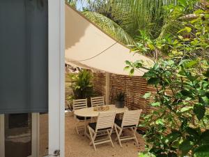 een patio met een tafel en stoelen en een parasol bij A2 APARTMENT budget at JAN THIEL Curacao in Jan Thiel