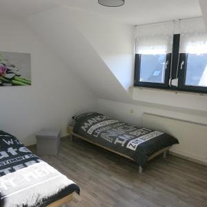 FewoSa Trier-Tarforst tesisinde bir odada yatak veya yataklar