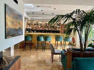 - un bar avec tabourets verts dans la pièce dans l'établissement The Village Boutique and SPA, à Naxxar