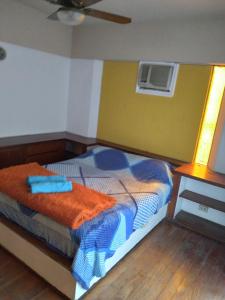 a bedroom with a bed with an orange blanket at T&A RESIDENCE Aeropuerto Ezeiza in Monte Grande