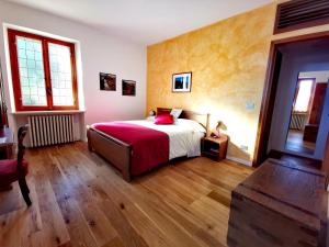 a bedroom with a bed with a red blanket at B&B Luna di Langa in Alba