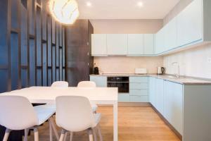 NEW! Apartamento Galé (wifi, estacionamento, elevador) 418 في بورتو: مطبخ بطاولة بيضاء وكراسي بيضاء