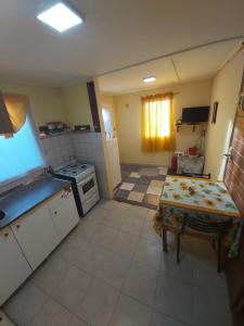 une petite cuisine avec une table et une cuisinière dans l'établissement Cabaña vivir #2, à El Chalten
