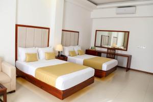 a hotel room with two beds and a mirror at Apna Colombo in Nawala