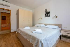 a bedroom with a large bed with towels on it at House Marija in Lopar