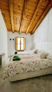 una camera con un grande letto e un soffitto in legno di La Cantarera a Linares de la Sierra