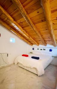 Cama en habitación con techo de madera en La Cantarera en Linares de la Sierra