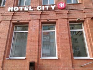 a hotel city sign on the side of a brick building at HOTEL CITY M in Saratov