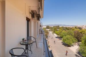 a balcony with a table and chairs and a street at Katsanis luxury apt., stunning view of acropolis in Athens